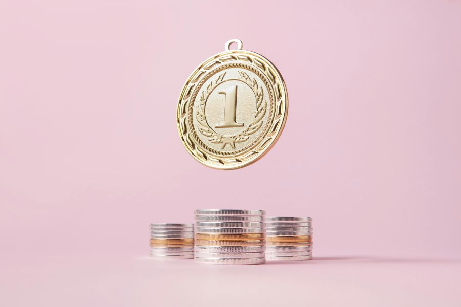 Gold medal hovers over stacks of coins